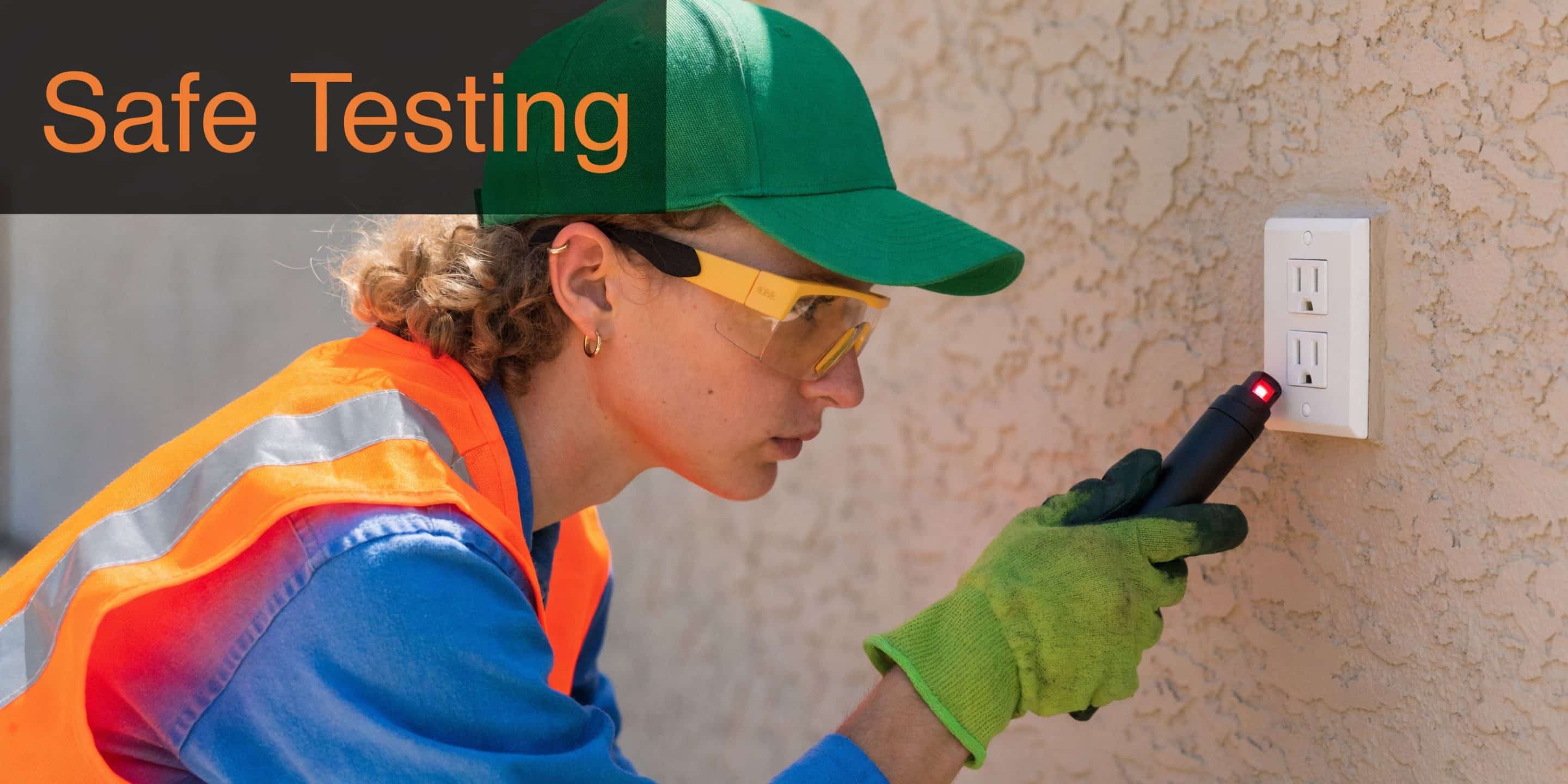 A construction worker wearing safety glasses uses a voltage tester to safely check an electrical wall outlet.